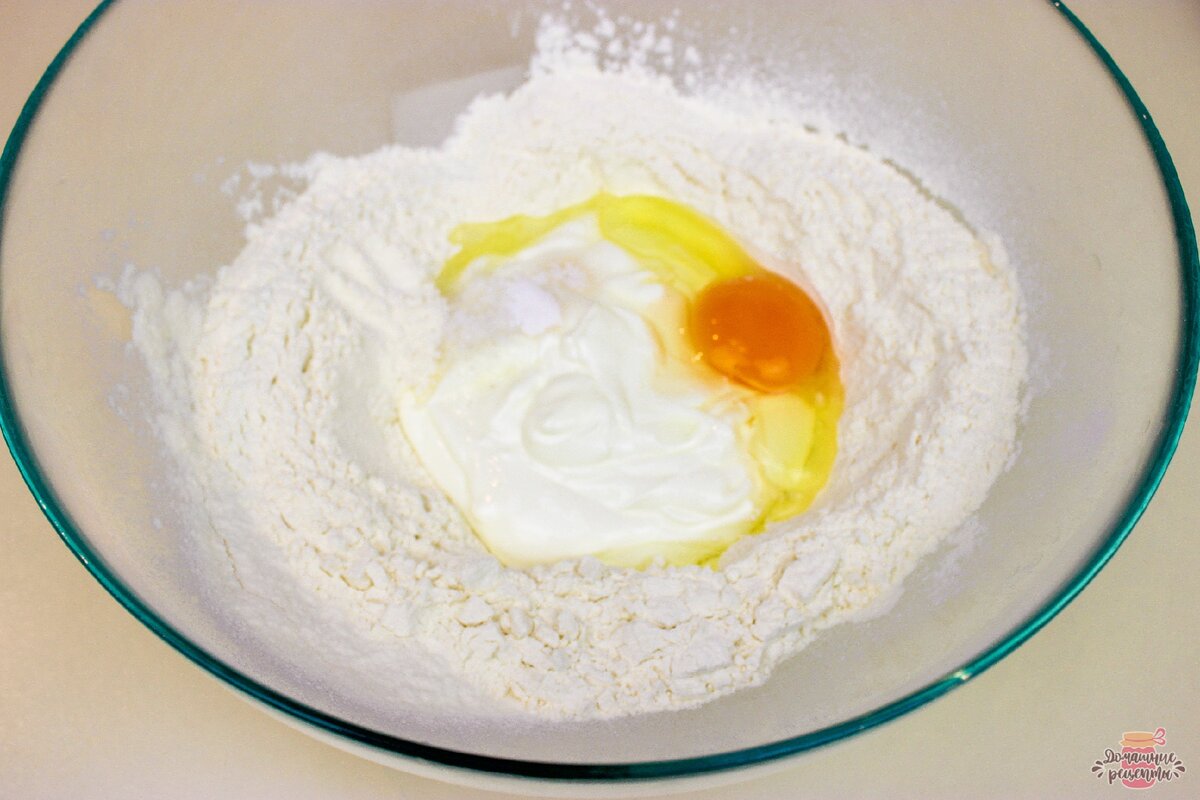 В муку добавляем сметану, яйцо, соль, соду и перемешиваем. Замешиваем тесто. При необходимости добавьте ещё муки.