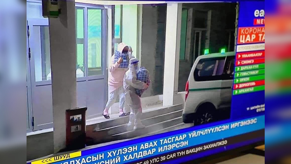 Фото "Монголия сейчас". Кадр из видео, где видно как роженицу вместе с ребенком выводят из роддома .