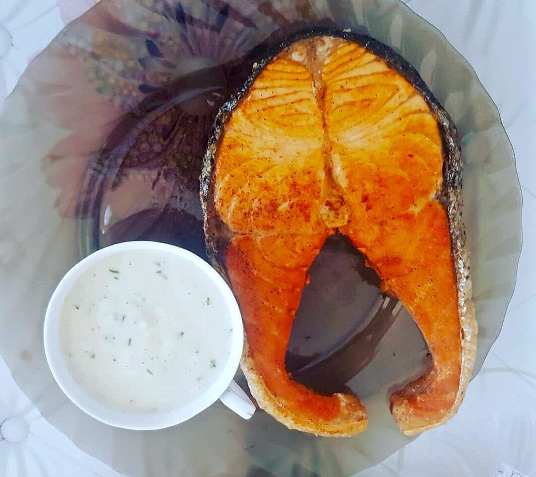 Стейк лосося с соусом из сметаны и пряных трав.