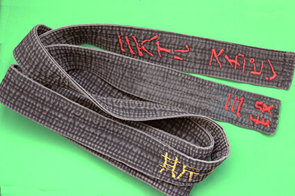 Мой первый чёрный пояс. Носил его с Шодан до Сандан. Кстати, под узлом вышита фамилия на китайском и название школы (не стиля!) - "Спящий дракон" по-китайски. Обратите внимание - линял, но не "тёрся"!