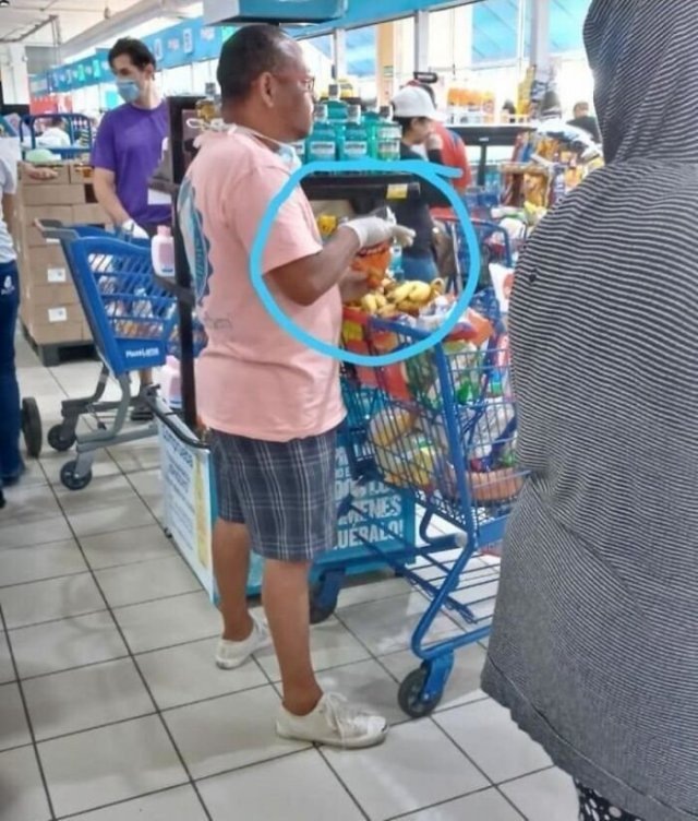 Смешное фото, мужчина в одноразовых перчатках берет орешки, для того, чтобы положить их в рот .