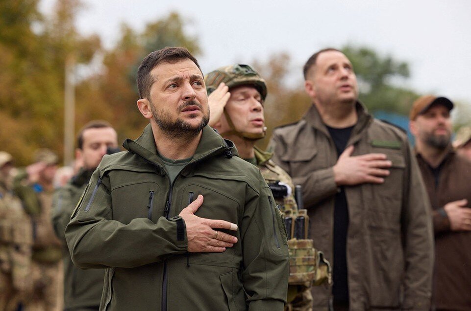     Зеленский поет гимн Украины на церемонии поднятии государственного флага в городе Изюм.  REUTERS