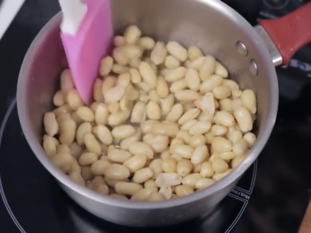 Теперь засыпаем арахис и непрерывно перемешиваем в течение двух минут.