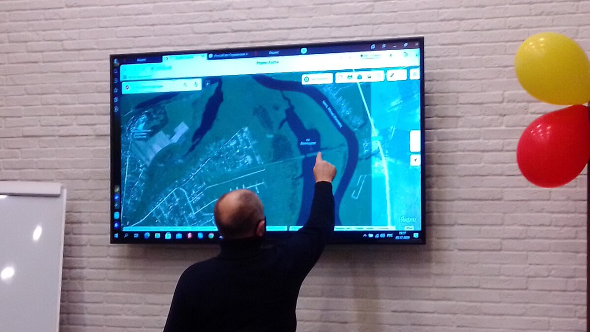 Яков Фёдорович Шох показывает на карте Новгородской области где до ВОВ 1941-45 гг. находилась Ново-Николаевская немецкая колония