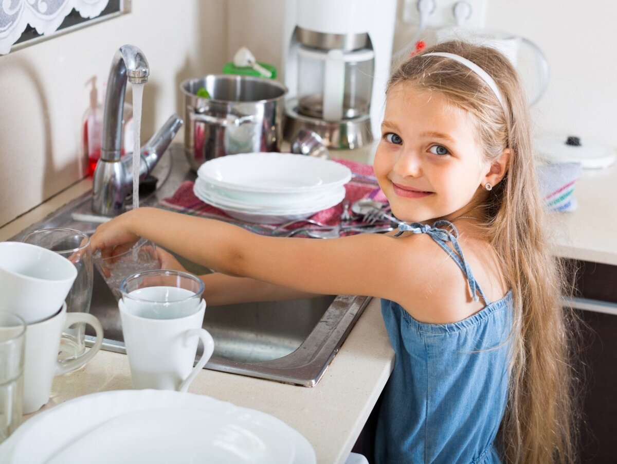 Девочка моет посуду