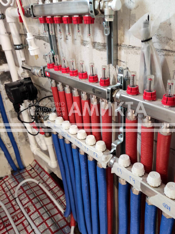 Монтаж распределительных коллекторов, отвечающих за направление потоков теплоносителя к радиаторам отопления, конвекторам и контурам водяного теплого пола - установка распределительного коллектора с расходомерами Stout 1х3/4 на шесть выходов, отвечающих за радиаторное и конвекторное отопление и коллекторов Stout 1х3/4 на семь и восемь выходов, управляющих системой водяного теплого пола. Фото с сайта https://amikta.ru/