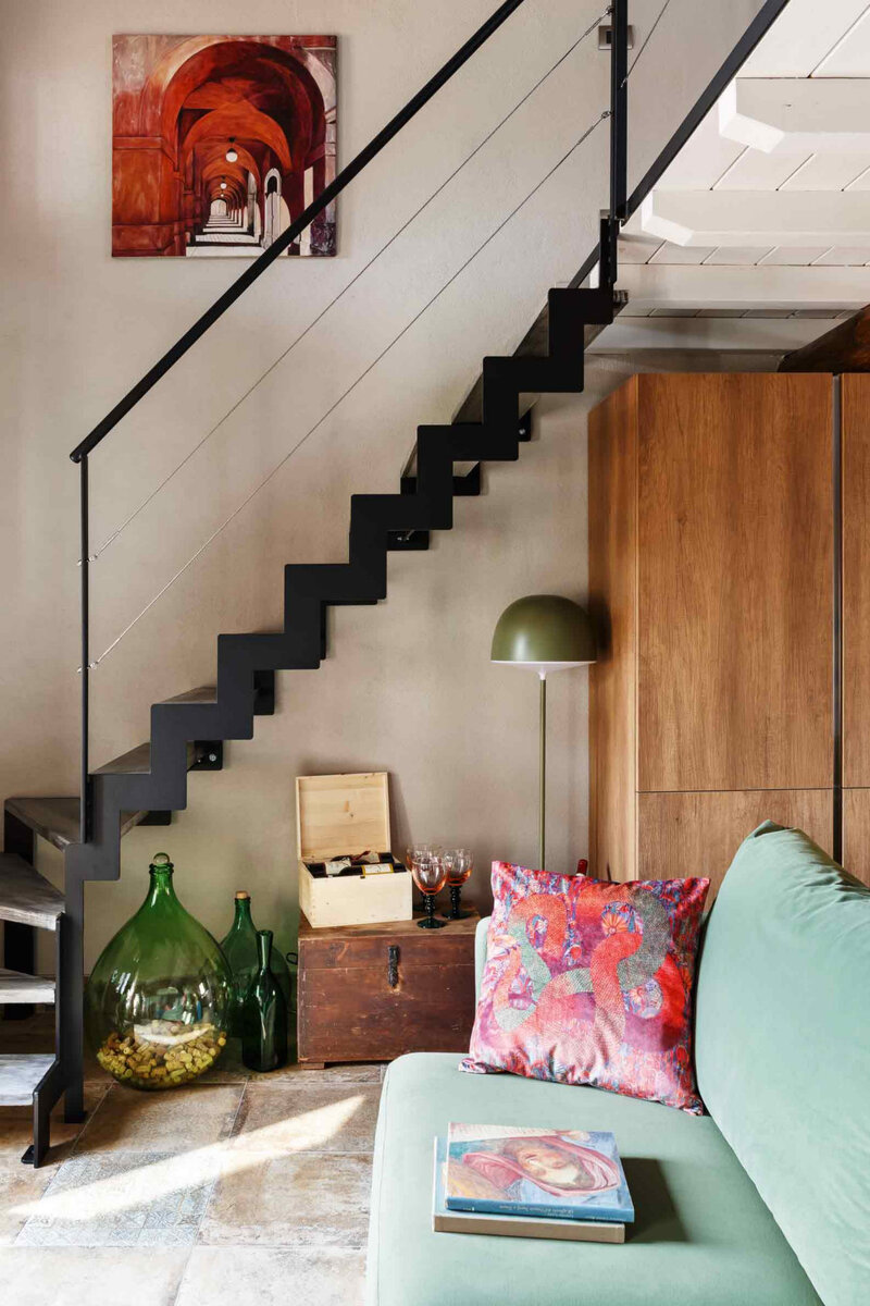 Фрагмент гостиной. Диван, Valmori Astor; торшер, FontanaArte; лестница по эскизам дизайнера; картина написана тоже ею.