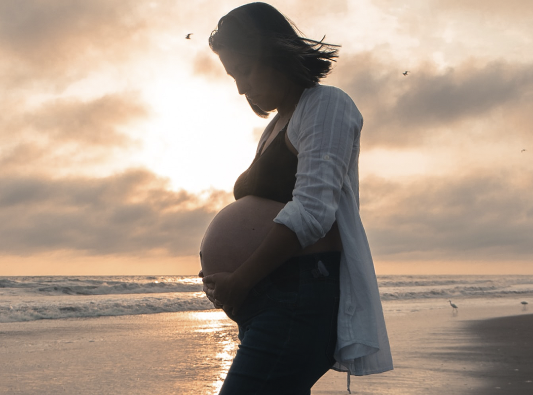 Беременная девушка на берегу. Источник: https://unsplash.com/photos/eMhF0tQ6WZM