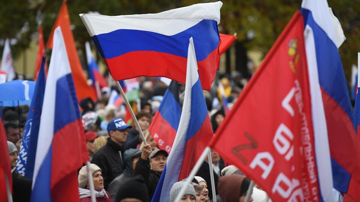    Люди с флагами во время митинга-концерта в честь присоединения ЛНР, ДНР, Херсонской и Запорожской областей к России в Центральном парке Новосибирска© РИА Новости / Александр Кряжев