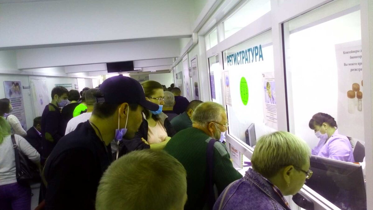 регистратура, слева и сзади толпа людей (нет на фото)