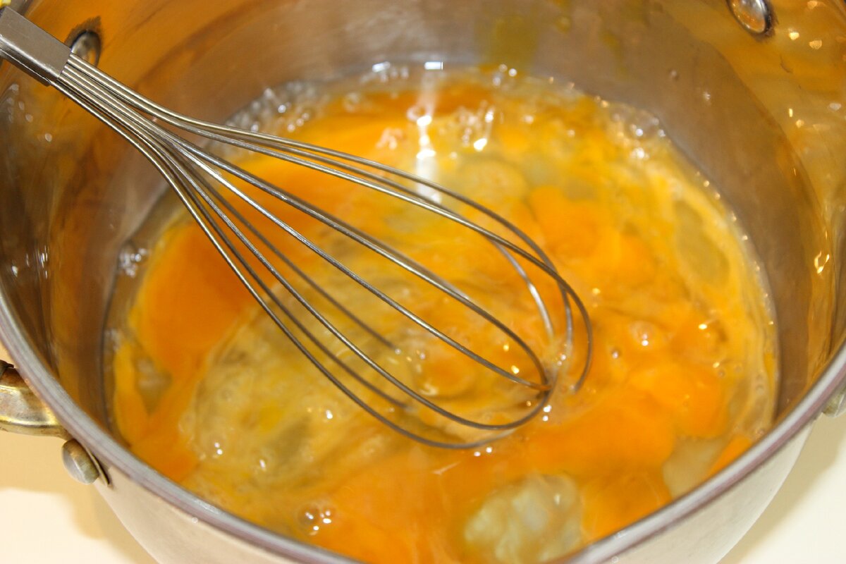 В кастрюле размешать яйца венчиком. 