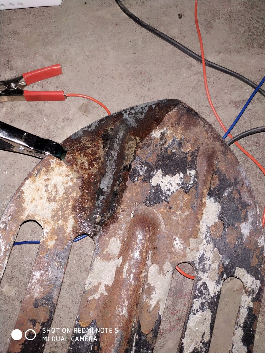 В том месте, где лопата мокрая, металл оцинкован. Это видно по характерному серому цвету.