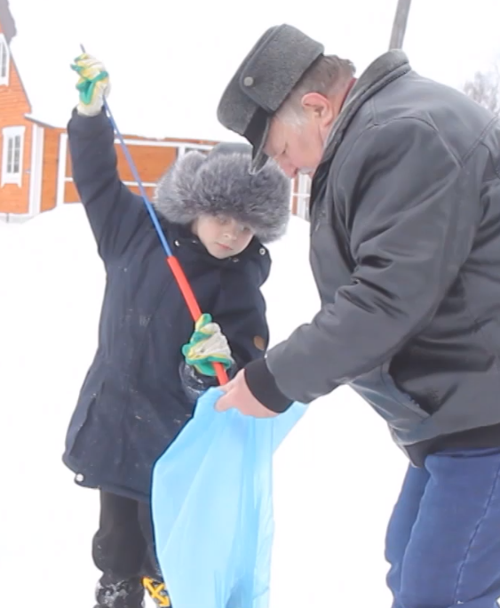 Вместе с дедушкой Матвей собирает мусор. 
