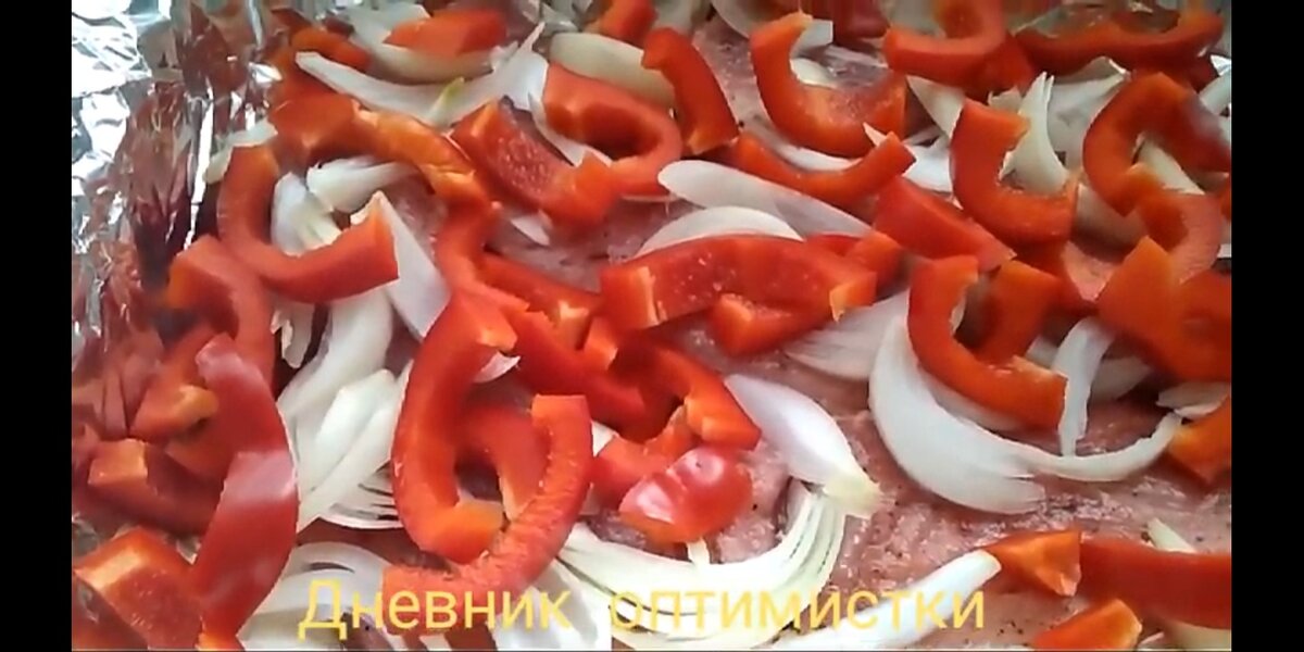 Подготовленное мясо положила на смазанную фольгу, сверху перец и лук. Фото автора.