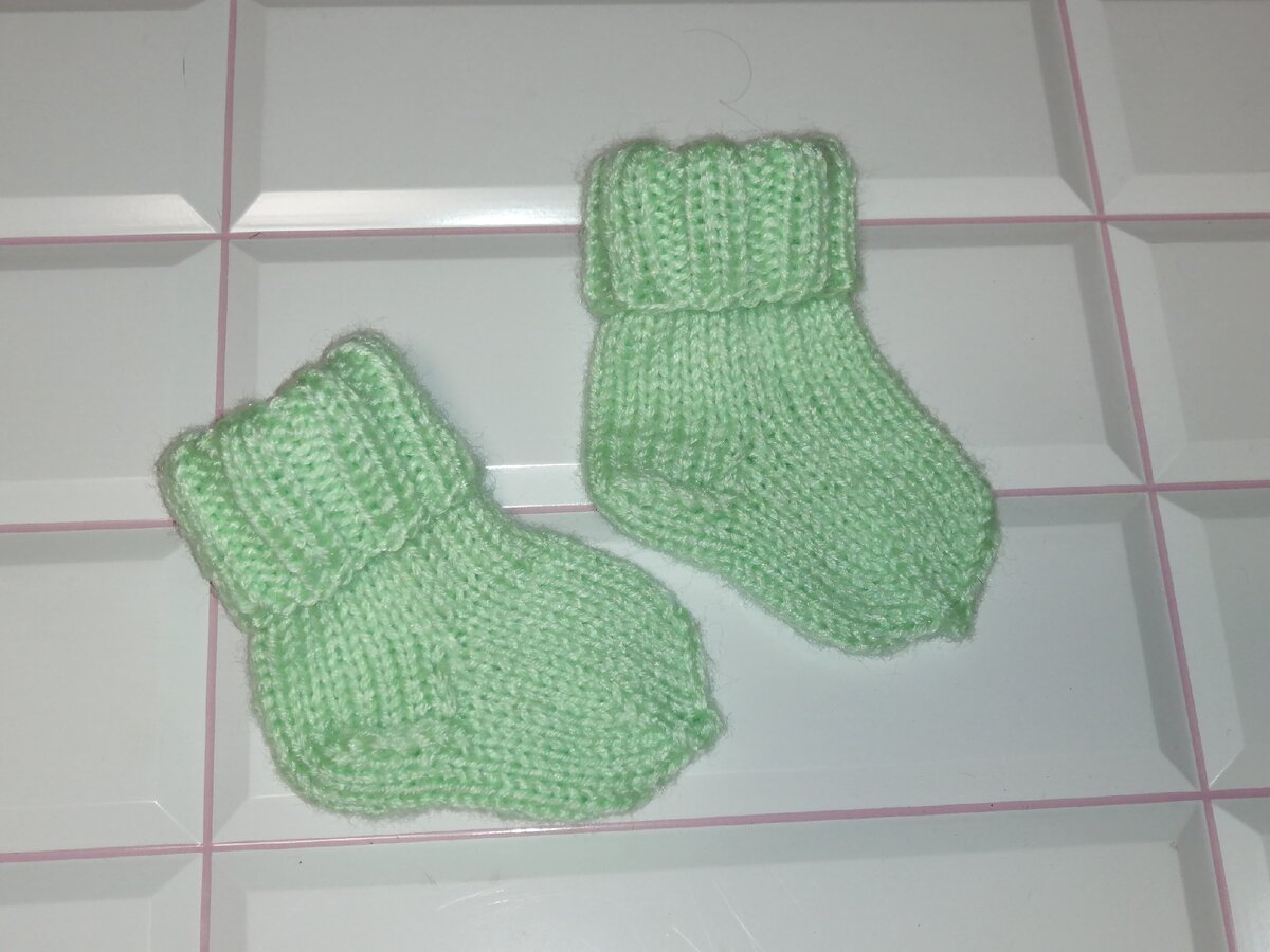 Носочки для новорожденных для начинающих. Носки для новорожденных спицами. Вязаные носочки для младенцев. Детские носочки спицами для новорожденных. Носки для новорожденных спицами для начинающих.