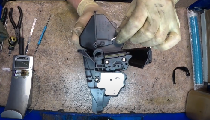 Фото 13. Поджимаем пружину, сжимающую две половины картриджа, и извлекаем фотобарабан