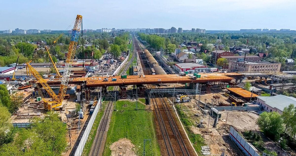 Общий вид.  Кран на северной стороне, но ни одна сторона не соединена.
 

 
00 Начинаем заход с южной стороны, подпорные стенки устоев готовы, но с юга их засыпать толком не начали то есть грунт в них не начал набирать несущую способность т.е. потом его сложно будет так затрамбовать чтобы он равномерно набрал несущую способность. Вобщем зря они пропускают весенние дожди.
 
[img=https://s26.postimg.cc/g2xt2m8fd/01-_Uj_Ustoy.jpg]
 
01 Вид с юго-запада вдоль всего путепровода.
 
[img=https://s26.postimg.cc/bh1ouaa1l/02-_DED.jpg]
 
02 Дед на месте второй опоры не просто окопался — он зеленеет и колосится и очень даже неплохо выглядит.
 
[img=https://s26.postimg.cc/subz94ahl/03-_Centr.jpg]
 
03 Центральный пролет. Высокой степени готовности, но не начат и не закончен. Потихоньку ковыряют.
 
[img=https://s26.postimg.cc/wdxwyyv7t/04_Cen_Prolet.jpg]
 
04. Еще ракурс центрального пролета. Похоже все на временных опорах пока смонтировано и недомонтировано.
 
[img=https://s26.postimg.cc/ol796zhix/05_Sev_Prolet.jpg]
 
05. На северной стороне устой заполнен и пролет из бетонных балок стоит. Но с февраля мало что поменялось.
 
[img=https://s26.postimg.cc/lr43tka7t/06_Sev_Exit.jpg]
 
06 А вот на северном выходе реально идет движение - освобождены оба участка справа-слева, что-то строят. Толи переходы толи части ливневки, но видно что серьезно, а в феврале там избы стояли.
 
[img=https://s26.postimg.cc/3ob12c6nd/07_Sev_Exit.jpg]
 
07. Еще один ракурс на северный выход — прям коллектор кладут городской.
 
[img=https://s26.postimg.cc/8zpxn285l/08_Sev_Prolet.jpg]
 
08 Такой общий вид с севера на все сооружение — впечатляет, конечно.
 
[img=https://s26.postimg.cc/vcxo9k3ux/09-_Centr.jpg]
 
09 Еще ракурс на центральный пролет - видно сколько секций смонтировано, видно несколько готовых постоянных опор, но стоит все на временных опорах — видимо части пролета надо по-другому скреплять друг с другом — а сейчас они просто "составлены".
 
[img=https://s26.postimg.cc/7lyari8tl/10-_Kran.jpg]
 
10 Кран, конечно, огромный и работа у него еще есть и на северной стороне и на южной. Неужели опять будут разбирать-собирать-перетаскивать?
 
[img=https://s26.postimg.cc/y70tmzybd/11_Ug_Podhod.jpg]
 
11 Завершаем облет видом на южную сторону, дед, конечно, феерично окопался. Есть фотки 4К, и некоторые промежуточные ракурсы, если кому что интересно - спрашивайте. Хостинг картинок - postimg.cc сегодня валялся пару часов но вроде очухался и неплохо вертится. Запасные на [url=https://yadi.sk/d/RBpiDV-T3VSTEw]яндексе[/url] в разрешении 1920. 
