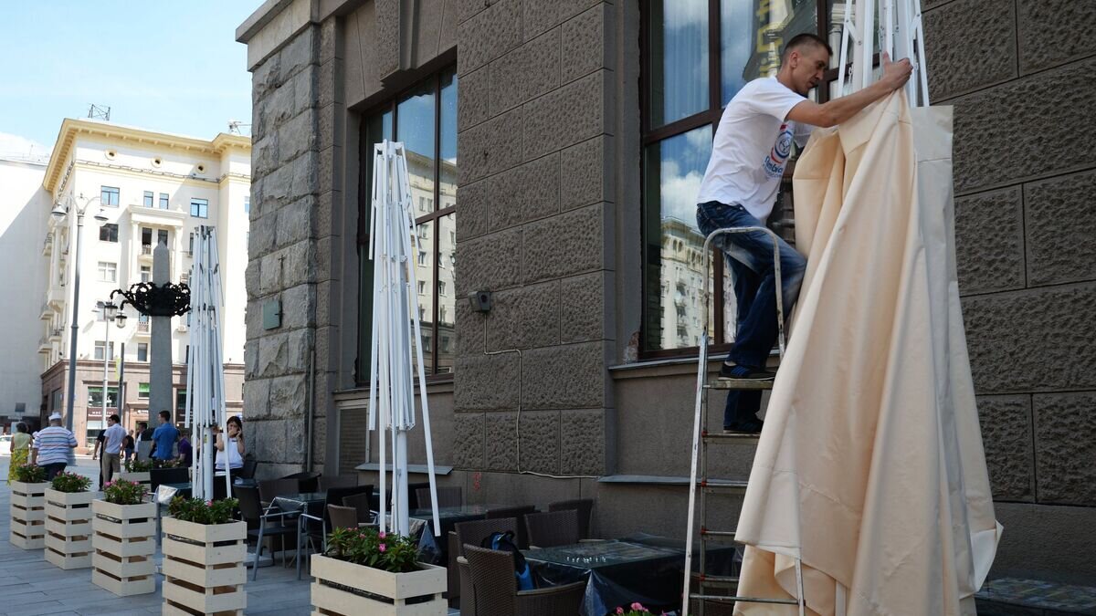    Рабочий устанавливает навес на летней веранде на реконструированной Тверской улице в Москве© РИА Новости / Кирилл Каллиников