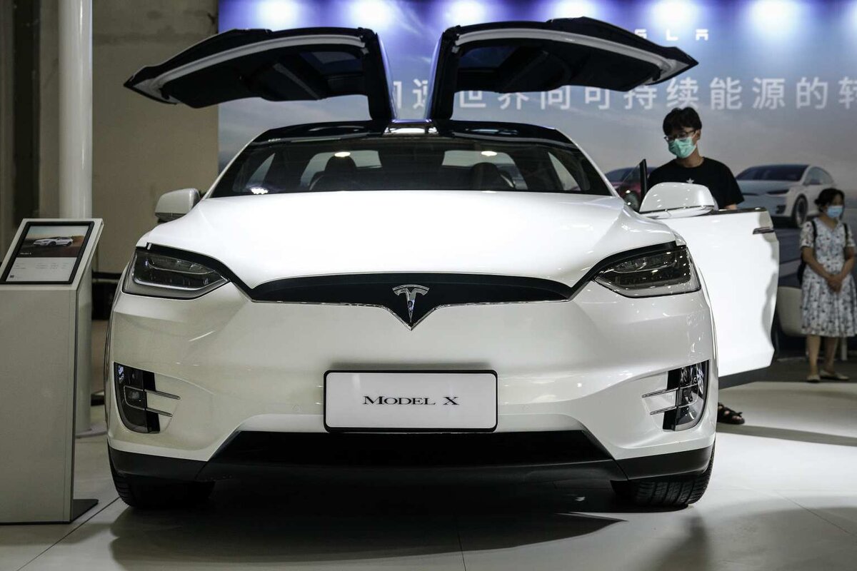 Участники в защитных масках осматривают стенд Tesla на 18-м Центрально-Китайском международном автосалоне 13 августа 2020 года в Ухане, провинция Хубэй, Китай. Источник фото Getty Images