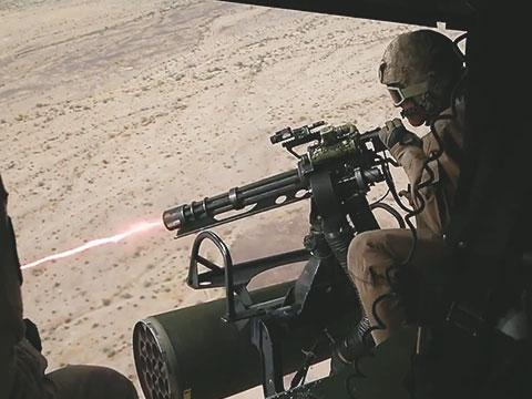 Пулемётчик ведёт огонь из боковой двери вертолёта из М134 "Миниган". Фото military.com