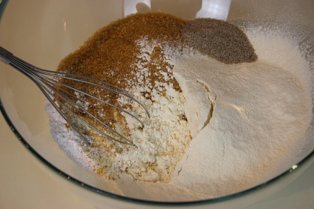 В чашке смешать сахар (лучше взять коричневый, он менее сладкий и с карамельным вкусом), манную крупу, муку просеять, разрыхлитель, ванильный сахар. Хорошо перемешать венчиком до однородности.