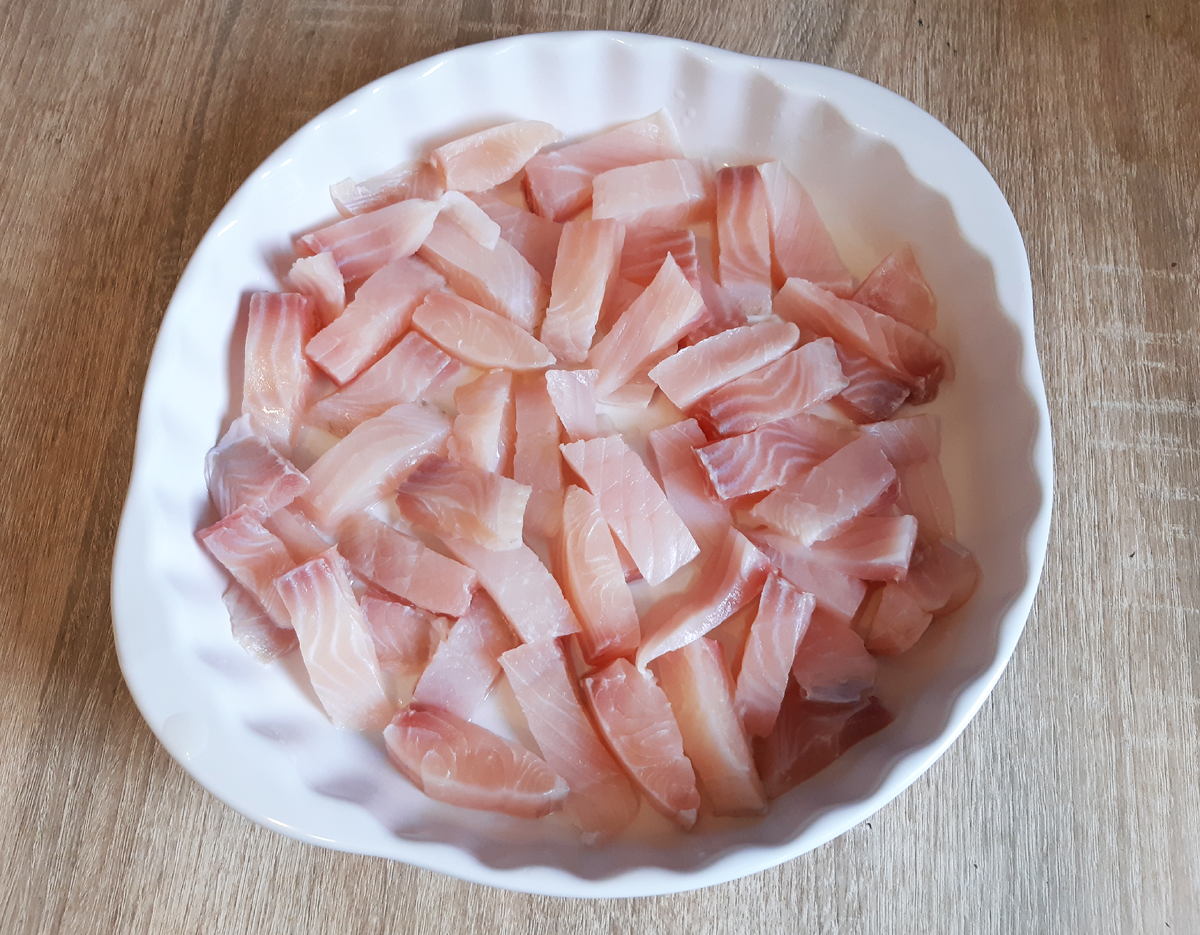 Смазываем форму маслом и укладываем рыбу.