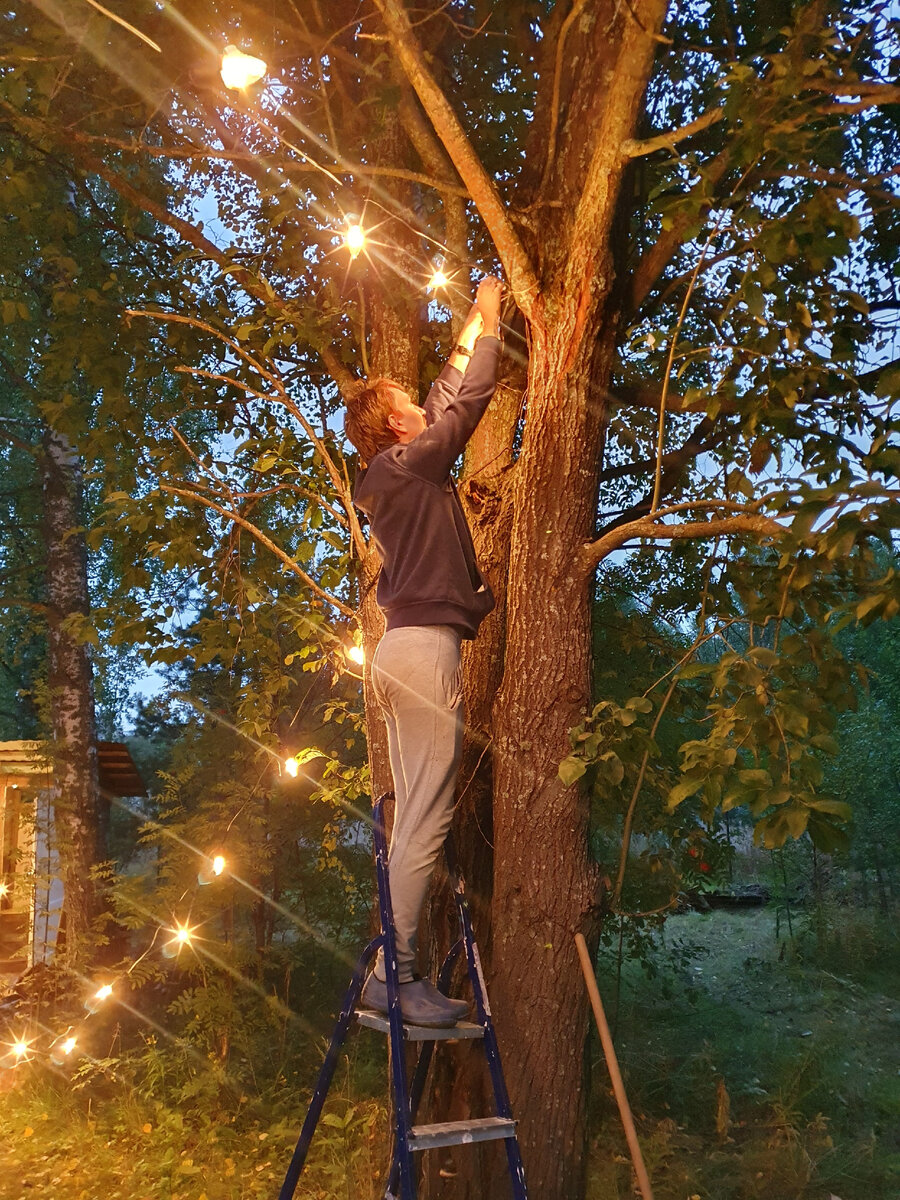 развешивали по простому, на ветках деревьев. Даже без использования троса. По хорошему, если вы планируете на постоянной основе вешать гирлянду, то  по воздуху её нужно вешать обязательно на натянутыйй трос.