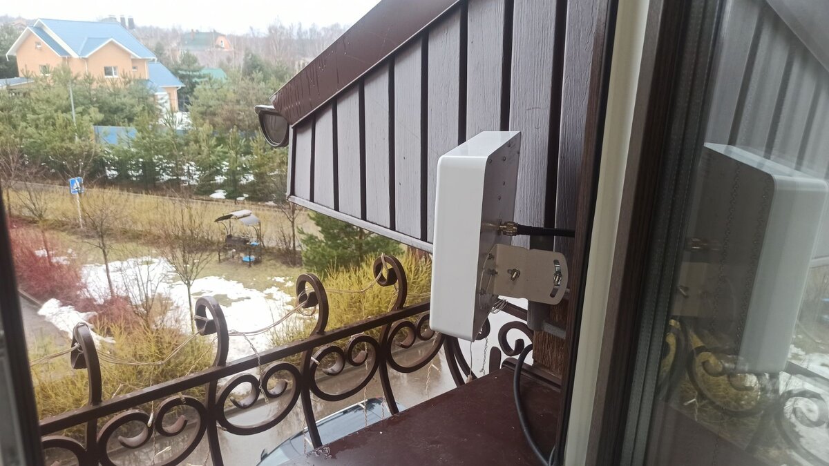 Внешняя антенна, принимающая сотовый сигнал, монтируется на фасаде дома.