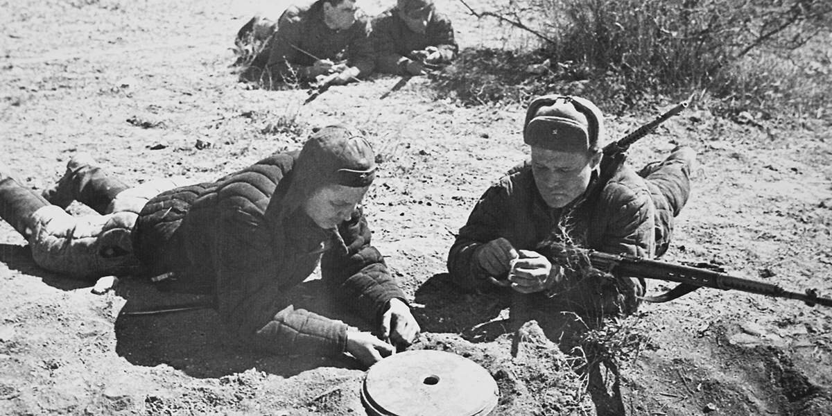 Советские сапёры-разведчики за обезвреживанием противотанковой мины. 
