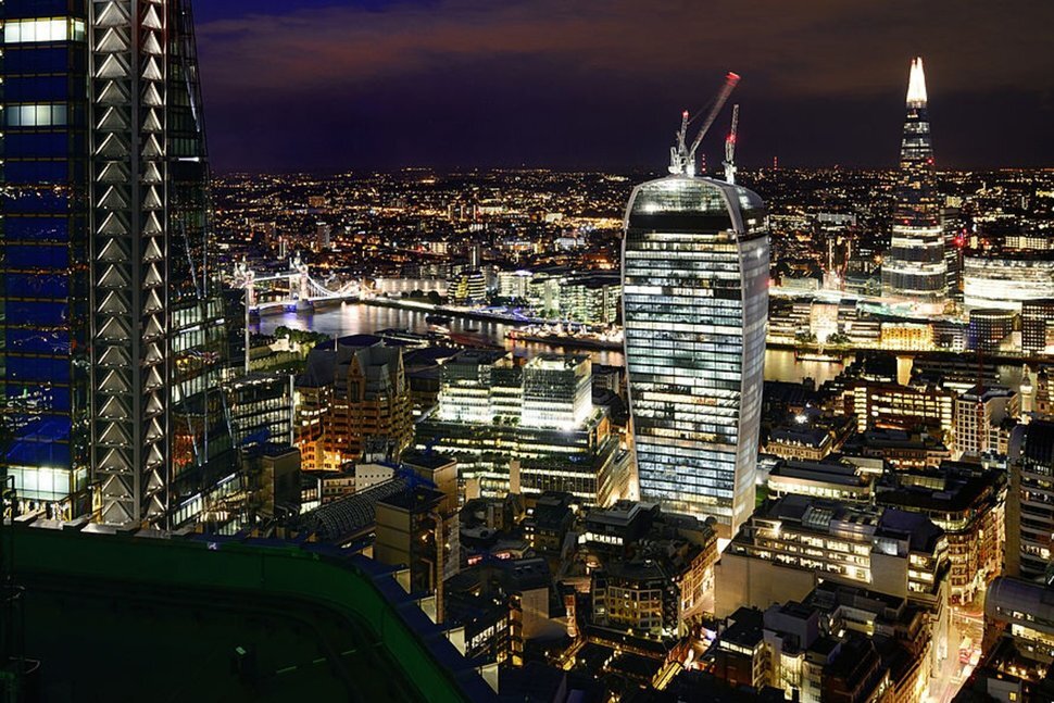 Возвышенный вид на Сити, финансовый центр Лондона, включая все совершенно новые небоскребы и Тауэрский мост ночью.
