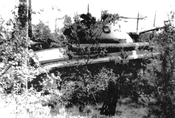 Т-10 в засаде. На манёврах Группы советских войск в Германии. Белая полоса справа на корпусе означает принадлежность танка к определённой стороне участников. Начало 1960-х гг.