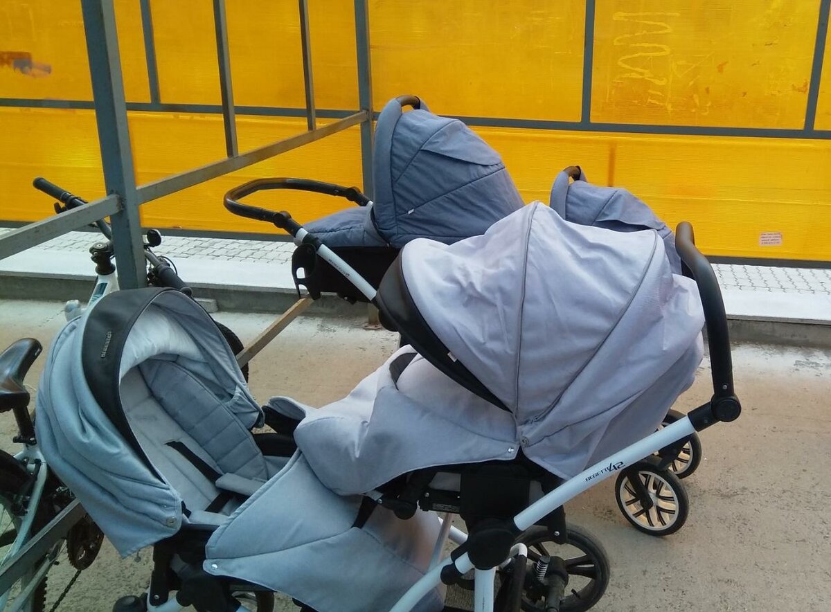 На колясочной парковке у детской поликлиники. Рядом с нами стоит коляска наших друзей-двойнят