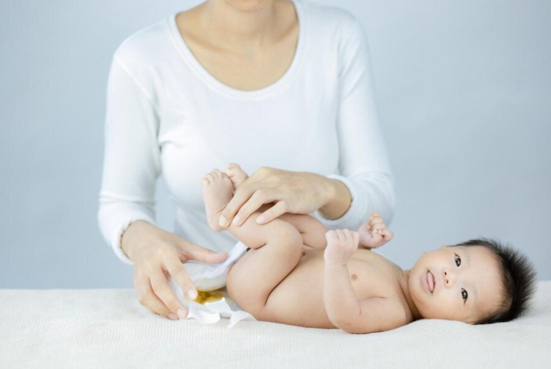    Мама меняет младенцу памперс:Freepik