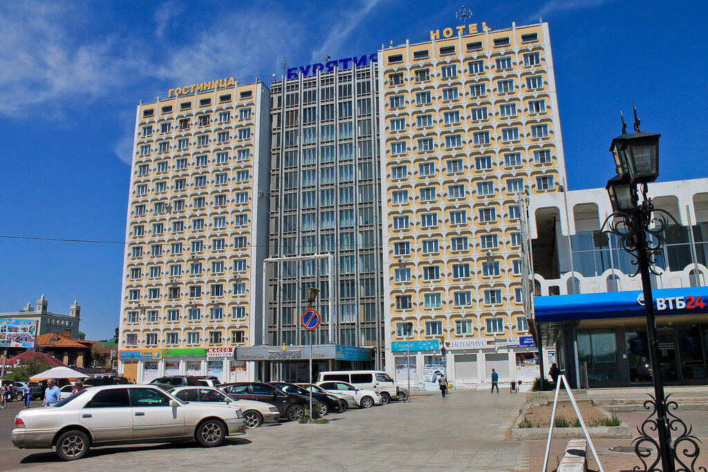 1. Начну я с фотографий гостиницы, в которой я останавливался на ночь.
Пожалуй, в любом российском городе - областном (республиканском, краевом) центре есть "главная" гостиница, выходящая на парадную площадь или улицу и носящая красивое лаконичное "географическое" название. Такова была традиция советского градостроительства.
Для Улан-Удэ - это отель "Бурятия", находящийся буквально в квартале от площади Советов.
Ужасно дорого, скажете? В летнее время - сезон отпусков и наименьшего наплыва командировочного люда - гостиница предлагает хорошие скидки. Так, одноместный стандартный номер обошелся мне всего в 1 400 рублей. Для самого центра города это совсем недорого.


