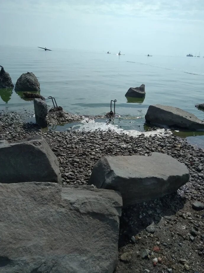 Кто-то плывёт, кто-то идёт по пояс в воде с лодкой...