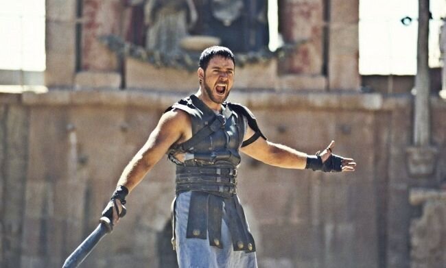 
 
Максимус — лучший полководец Марка Аврелия, великий человек и воин,  который не забывает про законы чести. После того, как император решает  присвоить Максимусу титул правителя Римской империи, его родной сын  Коммод поднимает бунт. Законный наследник убивает отца, а также жестоко  расправляется с семьей главного героя. Сам же Максимус попадает на  арену, где вынужден в гладиаторских боях сражаться за свою жизнь.
 
Идеальное с точки зрения драматургии и накала страстей кино. Ридли Скотт  грамотно поработал над сюжетом, при этом не забыв про важные  исторические детали. В итоге, мы получили фильм, воскресивший жанр  пеплум после долгого забвения.