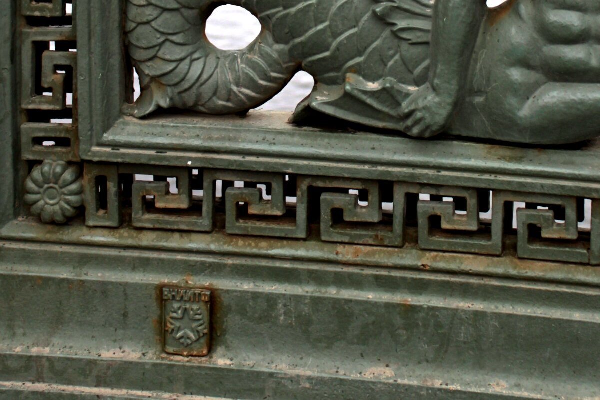 Герб Снежинска образца первой половины 90-х годов и надпись ВНИИТФ на одной из чугунных решёток Аничкова моста в Санкт-Петербурге