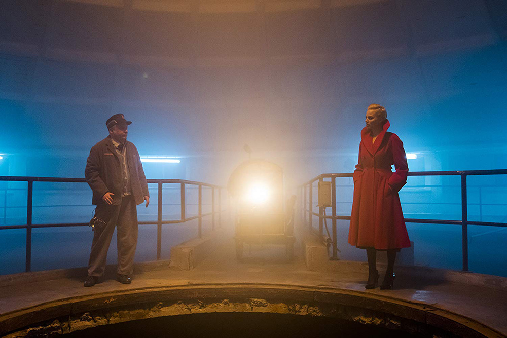 Фильм в первую очередь впечатляет визуальными решениями и атмосферой неонуара. Действие ленты разворачивается в некоем загадочном мрачном городе, кстати, – раз уж мы вспомнили Харли, – похожем на Готэм, где никогда не светит солнце, а улицы кишат гангстерами и наркодилерами. Несмотря на стилистику, фильм не торопится «гасить цвета», как это было в том же «Городе грехов»: когда атмосфера сцены требует ярких красок, то лента не стыдится их предоставить. Ретростилистика костюмов и декораций добавляет картинке таинственности, а кричащие цвета, сопровождающие главных героев и резко контрастирующие с сумраком проулков и тупиков, не могут не впечатлять – лента снята с большим визионерским талантом. Даже если сюжет покажется вам невнятным и путаным, «Конченая» заслуживает просмотра хотя бы за дивное красное пальто героини Марго Робби, которое не скоро сотрется с сетчатки ваших глаз. Можно сказать, что именно кричащий красный цвет является основным лейтмотивом фильма, ассоциируясь не только с вышеупомянутым нуаром и, соответственно, с кровью, но и, как абсурдно это ни прозвучит, с Королевой Червей из общеизвестной книги Кэрролла.