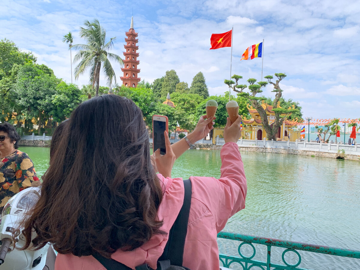 Вьетнамки делают фото на фоне пагоды в Ханое
