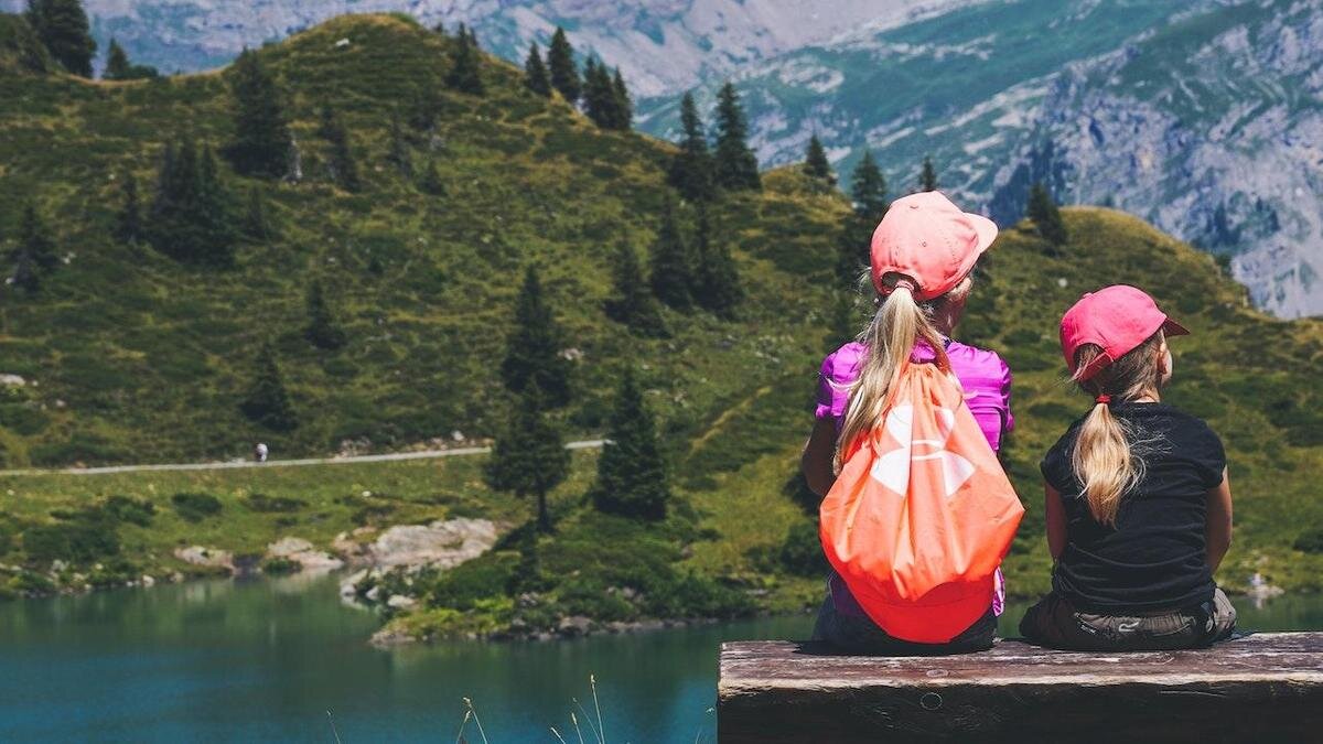    Две девочки сидят у озера в горах:pexels.com