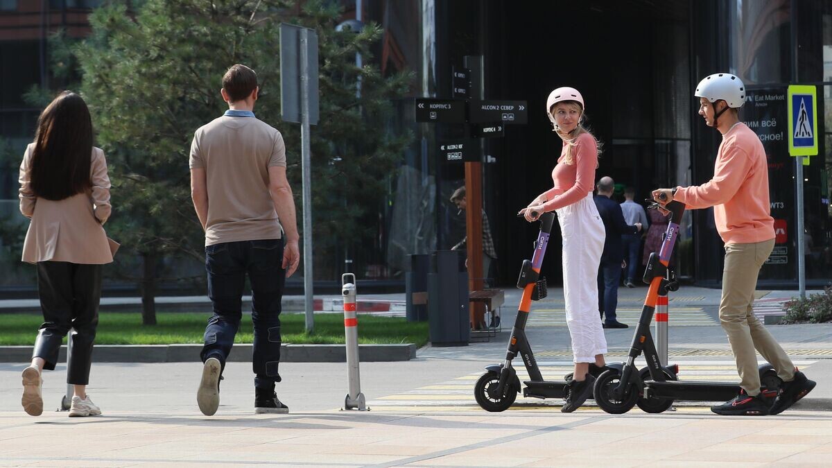    Молодые люди катаются на прокатных электросамокатах в Москве © РИА Новости / Антон Денисов