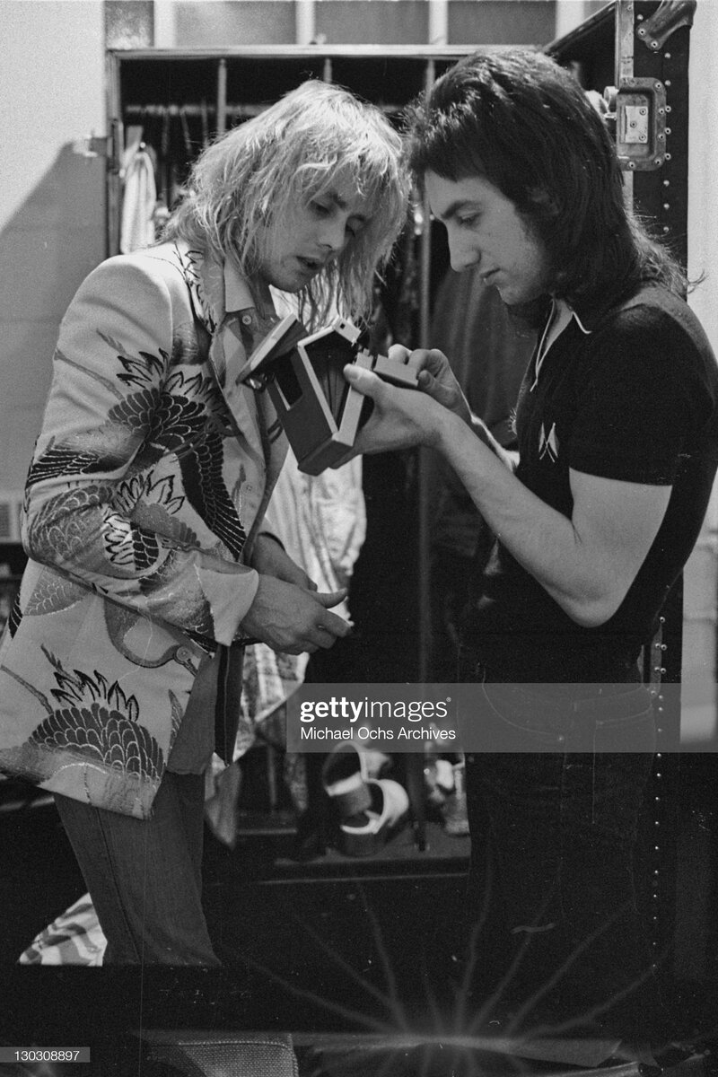 Roger And John Musicians John Deacon and Roger Taylor of British rock band Queen with a Polaroid camera backstage, circa 1977. (Photo by Michael Ochs Archives/Getty Images)