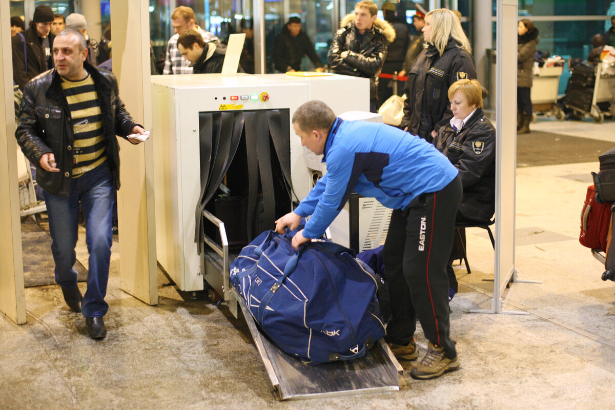 Пассажиры забирали багаж. Аэропорт с пассажирами внутри. Пассажиры забирали багаж. Пассажиры забирали багаж. Багаж в аэропорту.