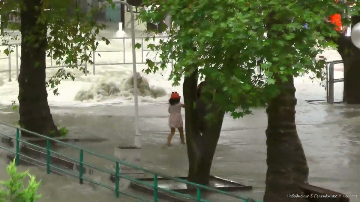 Ребенок смотрит на "извержение" воды из канализационной системы