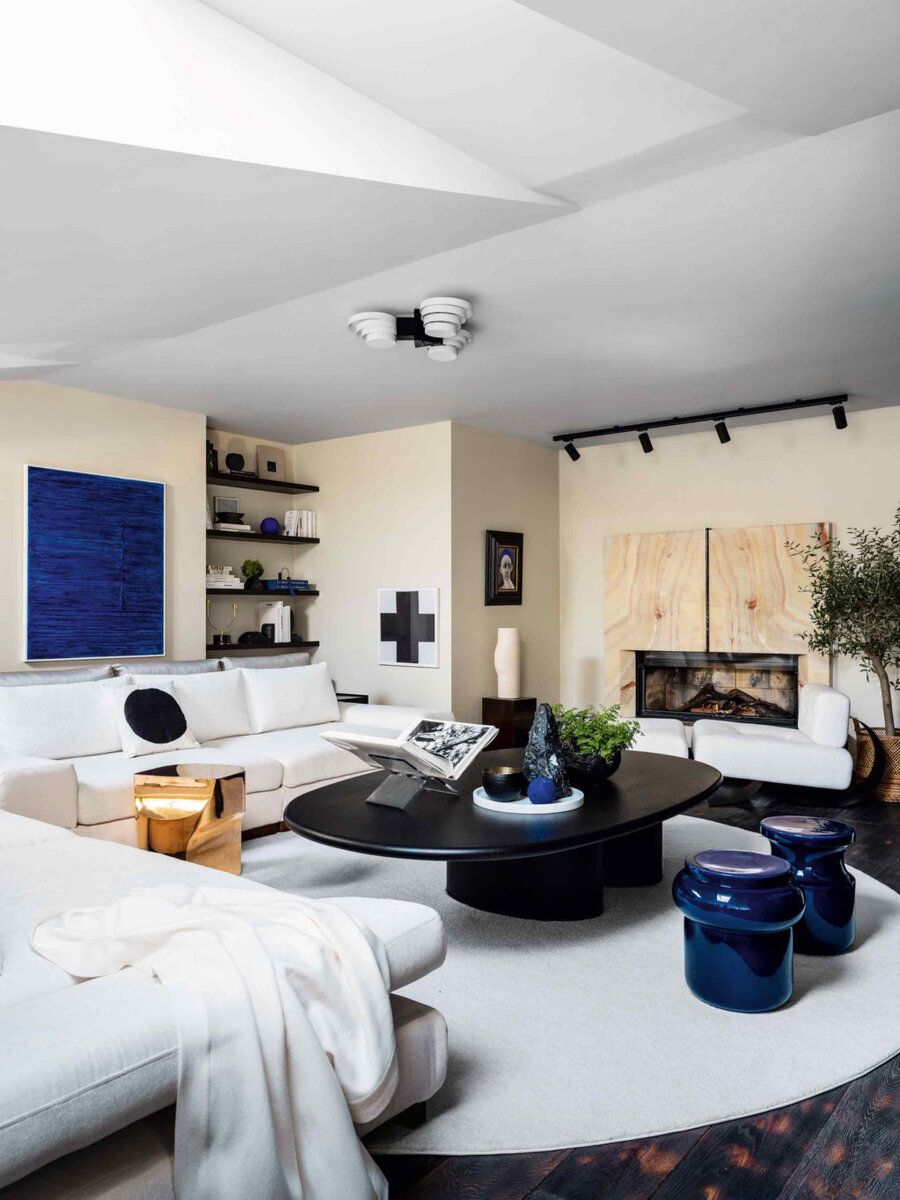 Гостиная. Диванная группа осталась от прежних жильцов, ее обтя­нули новой тканью; винтажный светильник Olympus, Raak; синие и бронзовый столики, Christophe Delcourt; каменные аксессуары и ваза из Booroom Gallery; синяя картина Софьи Ивановой; постер ­Казимира Малевича; картина Адиля Аурбекова из PA Gallery.
