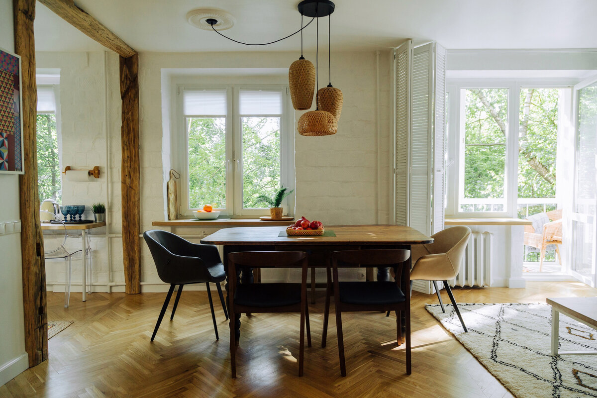 Обеденный стол крупным планом. Кстати, это настоящий винтаж! Купеческий стол XIX века. Слева — вход в кухню, отделанный деревом. Необычный интерьерный ход. Кстати, кухня в этой квартире предназначена не только для приготовления пищи. Там есть уютное небольшое пространство для завтраков или обедов