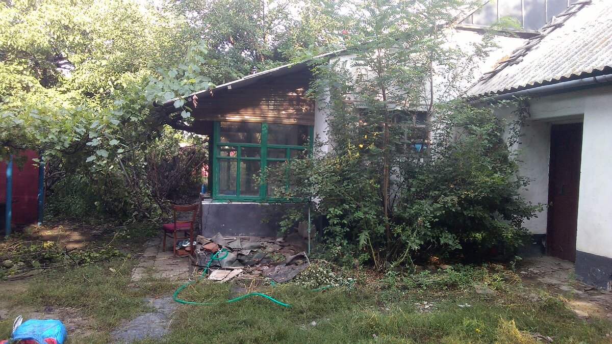 а это уже 25 июля.. вход со стороны сада, я уже..   видно что уже наполовину убран завалившийся виноград спереди, а тут я опустил в колодец свеже купленный насос и пока шлангой через чердак кидаю в дом воду... кстати шивер над коридором пришлом передвигать а то протекала...