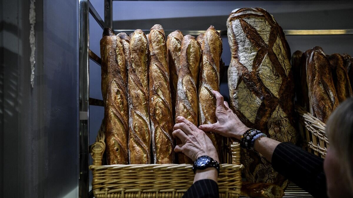 Покупатель выбирает хлеб в булочной в Париже © AFP 2022 / Christophe Archambault