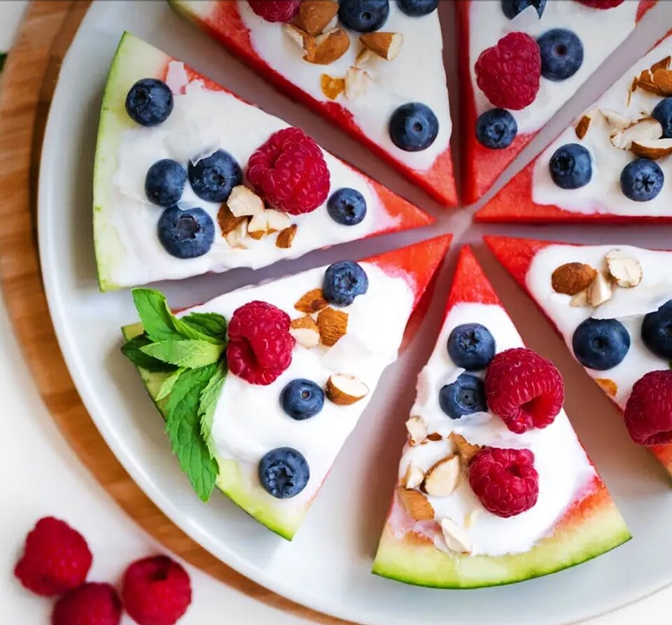 Арбузная пиццаОбожаете пиццу? Я понимаю, что эта арбузная пицца мало похожа на итальянскую классику, но это не значит, что она не вкусная! Ее очень легко и быстро готовить, примерно в два раза быстрее, чем обычную пиццу.Ингредиенты для 1 порции:• арбуз (350 г)• обезжиренная творожная масса(без добавок) (60 г)• черника (40 г)• малина (40 г)• свежая мята (по вкусу)• кокосовые чипсы (5 г)• миндаль, рубленый(1 ст.ложка, 8 г)• лимонный сок(1 ч.ложка, 5 мл)Инструкции по приготовлению 1 порции:1. Разрежьте арбуз пополам, а затем отрежьте один толстый кусок, который будет основой "пиццы".2. Разрежьте этот кусок на 8 частей словно пиццу.3. Выложите на каждый кусочек творожную массу и украсьте черникой, малиной, мятой, кокосовыми чипсами и миндалем.4. Сбрызните каждый кусочек лимонным соком и подавайте.5. Приятного аппетита!