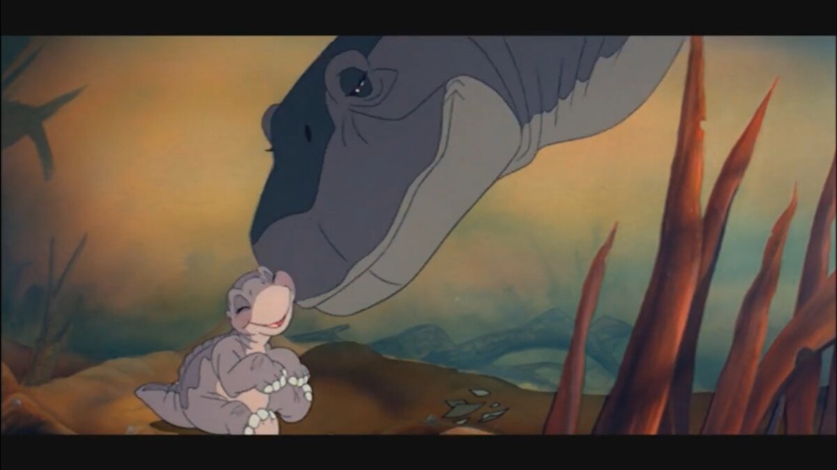 На двух маленьких динозавров — Литтлфута и Сэру — нападает громадный хищник Острозуб. Мать Литтлфутта спасает их, но сама погибает в сражении. Сцена этой смерти — одна из самых смелых в подборке, фильм не пытается смягчить или приукрасить ситуацию. 
Кадр с бездыханном телом матери и ее сыном на фоне дождя остается надолго не только на экране, но и в памяти зрителей. Смерть происходит в начале истории: до относительно счастливого конца остается еще достаточно событий, и печальное настроение будет «просвечивать» во всем оставшемся повествовании.